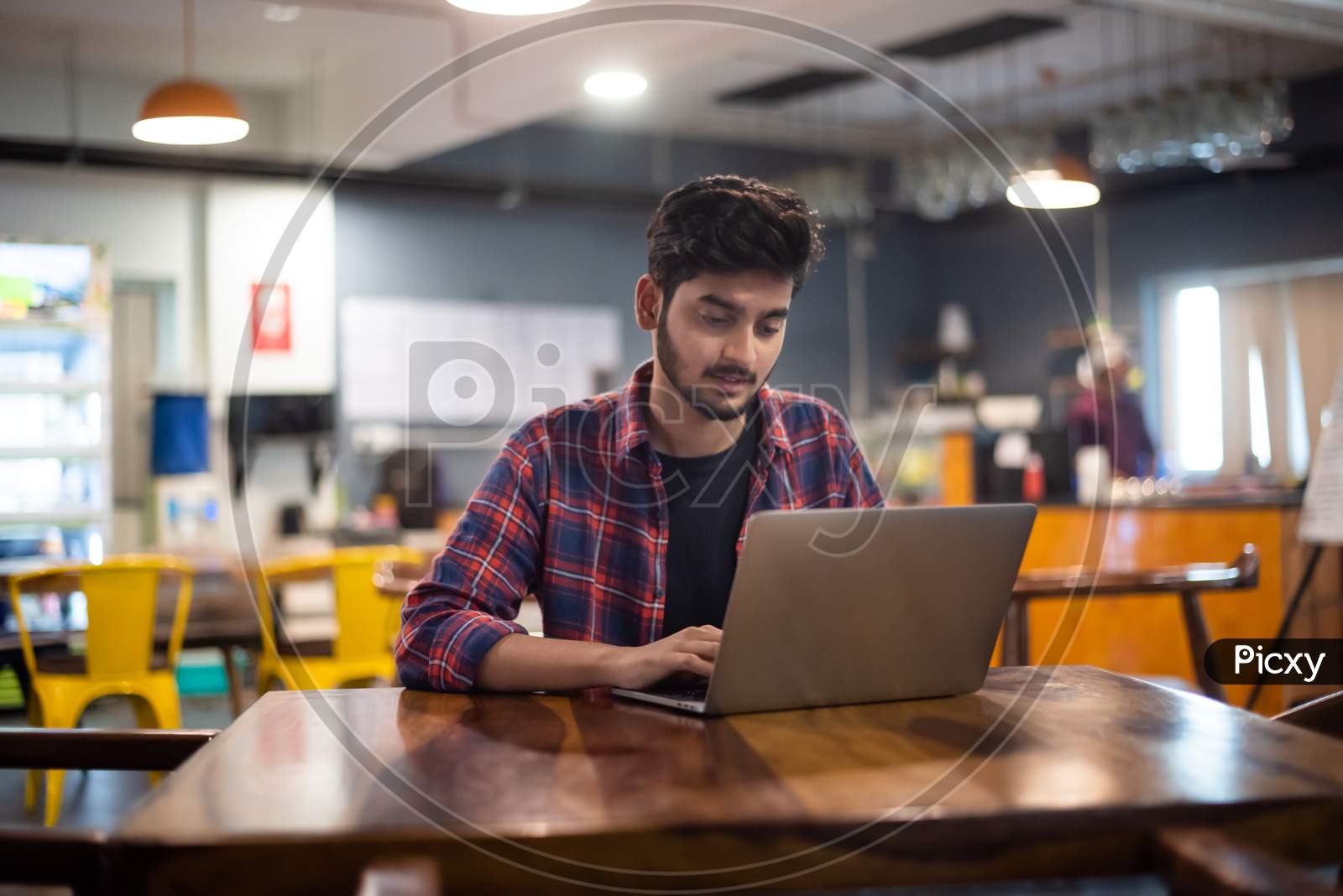 Young Indian professional Man working on a laptop in office.
