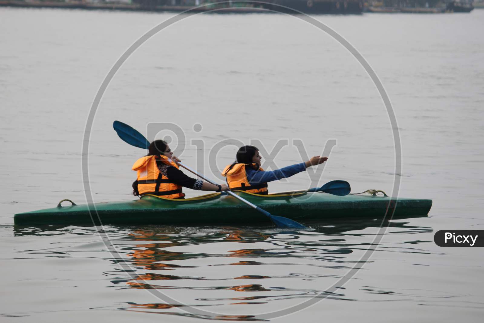 Water background with Two random people with life jacket rowing boat on a evening, at 'Eco Park'