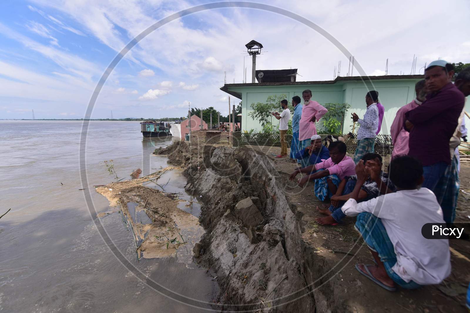 Villagers Stand Next To A School And Mosque That Collapsed On The Banks Of Brahmaputra River Owing To Soil Erosion during the floods, At Bhurbandha Village In Nagaon District Of Assam On July 25,2020