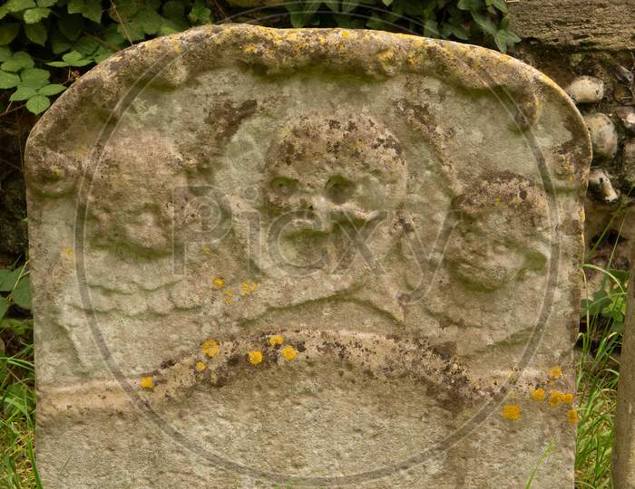 2 Cherubs And A Skull On An Old Ornate Weathered Gravestone In E