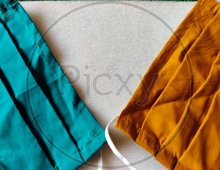 Blue And Orange Color Face Mask Made From Cloth Placed On White Background. Medical Type Mask For Coronavirus Protection