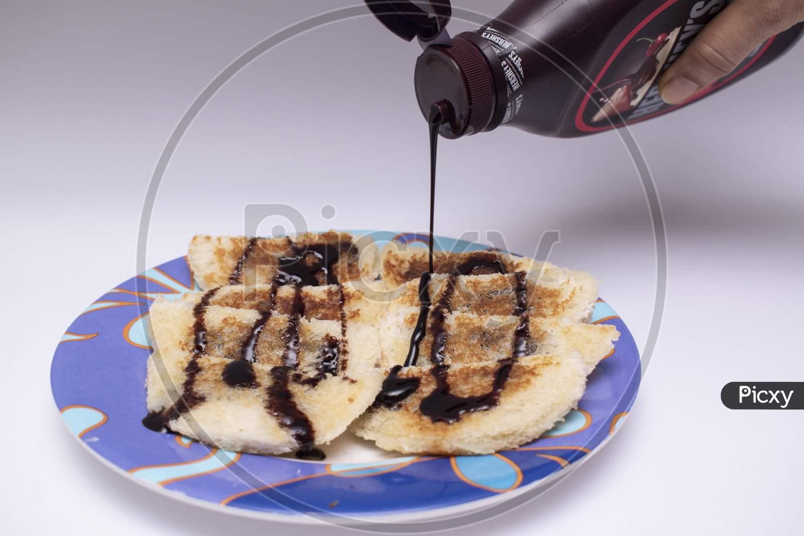 Decorating Hot Choco Lava Bread By Pouring And Garnishing With Chocolate Syrup Or Sauce