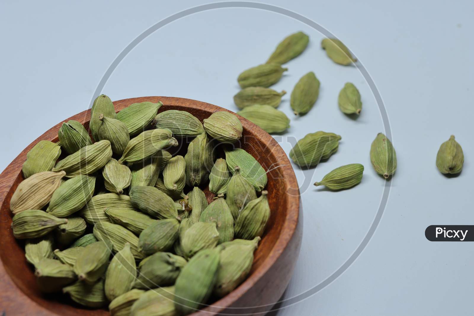 Small pile of green cardamon seeds isolated on the white background