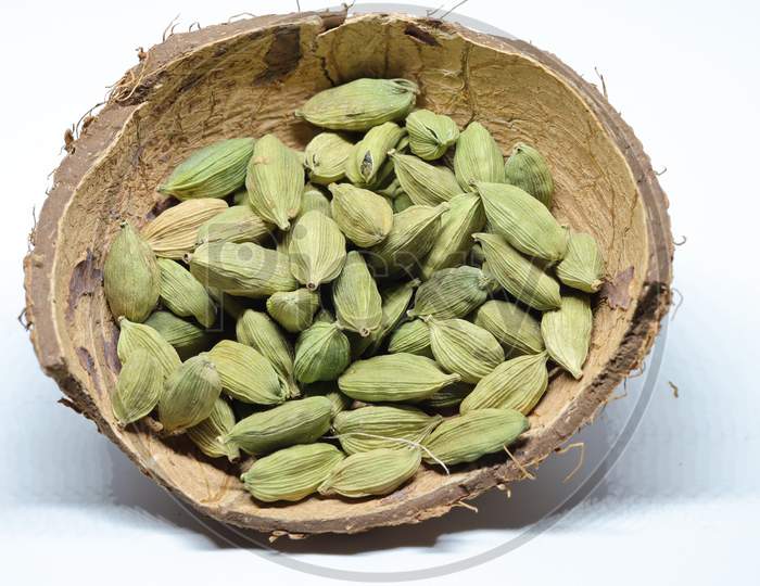 Small pile of green cardamon seeds isolated on the white background