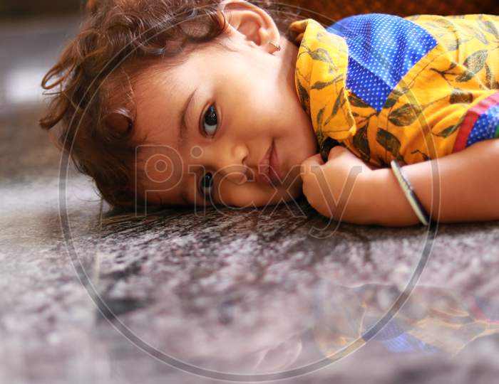 A Child Lying On The Marble Floor