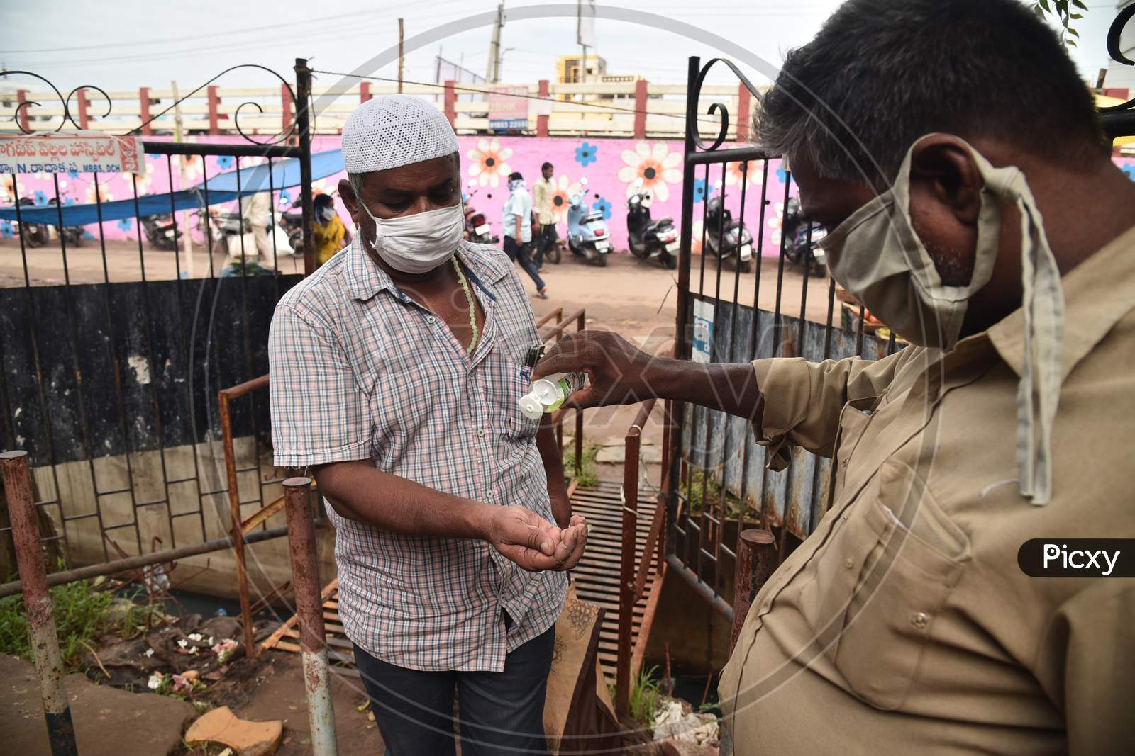 A Customer Gets His Hands Sanitized Before Entering A Vegetable Market In Vijayawada.