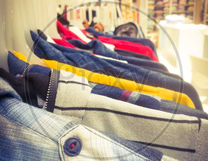 Right Side View Of An Array Of Shirts Hanging In A Bar Inside Textile Showroom.