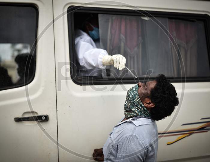 A Medic Collects A Swab Sample Of Man For The Covid-19 Test From A Swab Collection Van In Vijayawada.