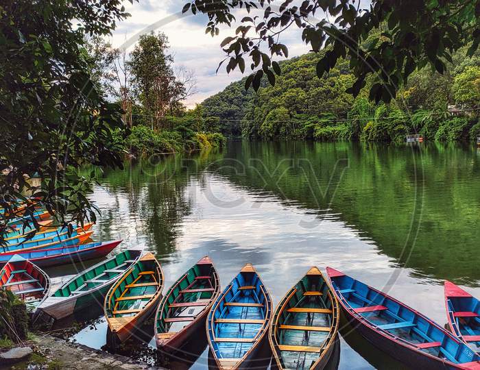 This photo is about a lake with boats resting in the water peacefully.