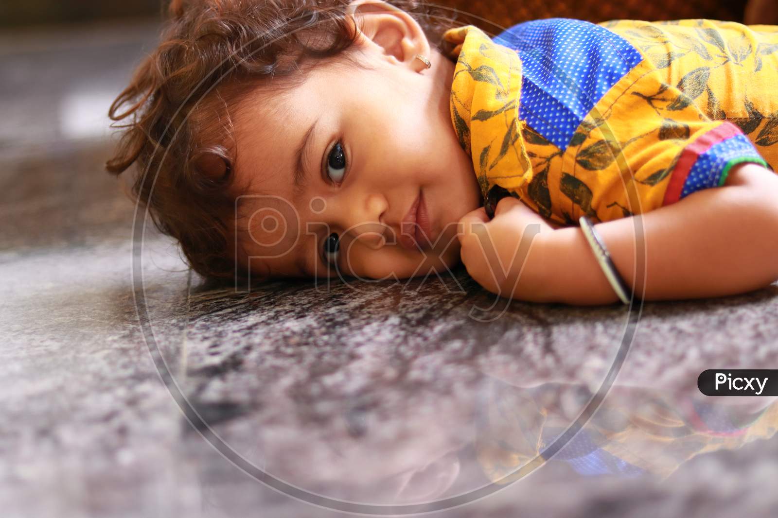 A Child Lying On The Marble Floor