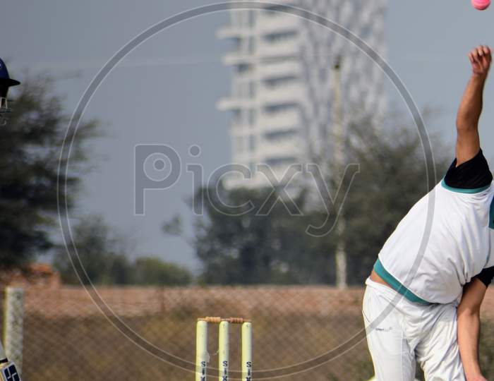 New Delhi India – March 3 2020 : Full length of cricketer playing on field during sunny day in local playground, Cricketer on the field in action, Players playing cricket match at field