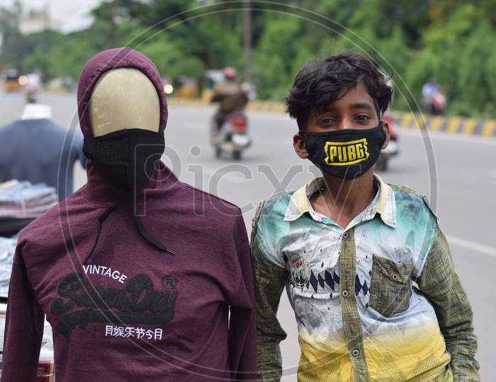 Hyderabad, Telangana, India. july-22-2020: wearing a mask to the doll, a boy standing next to the toy at road side, corona pandemic time