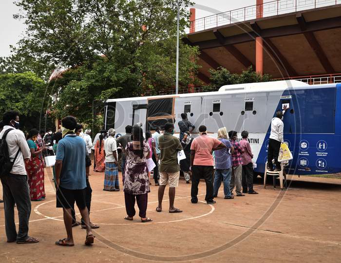 People Wait Near A Swab Collection Vehicle For The Covid-19 Test At Igmc Stadium In Vijayawada.