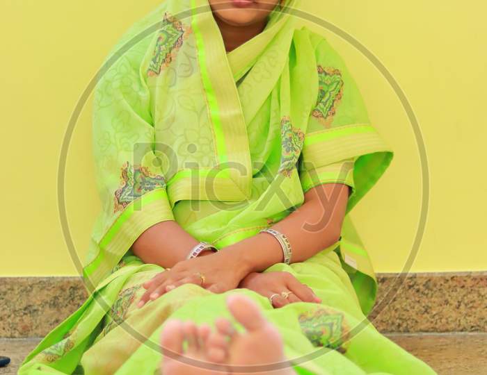 Indoors Model Woman Sitting On Floor And Showing Green Saree Design
