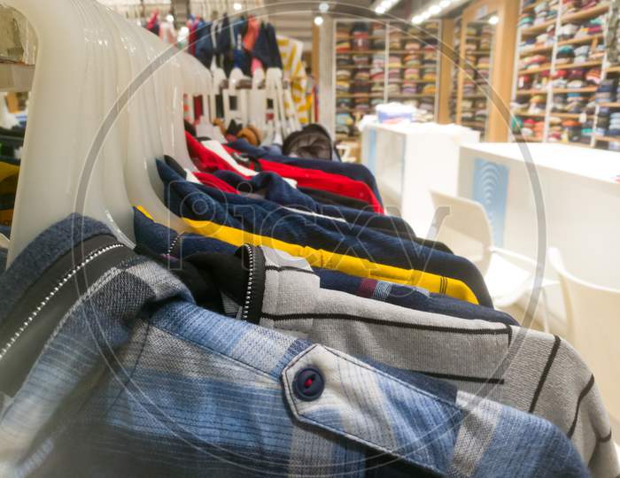Right Side View Of An Array Of Shirts Hanging In A Bar Inside Textile Showroom.