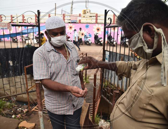 A Customer Gets His Hands Sanitized Before Entering A Vegetable Market In Vijayawada.