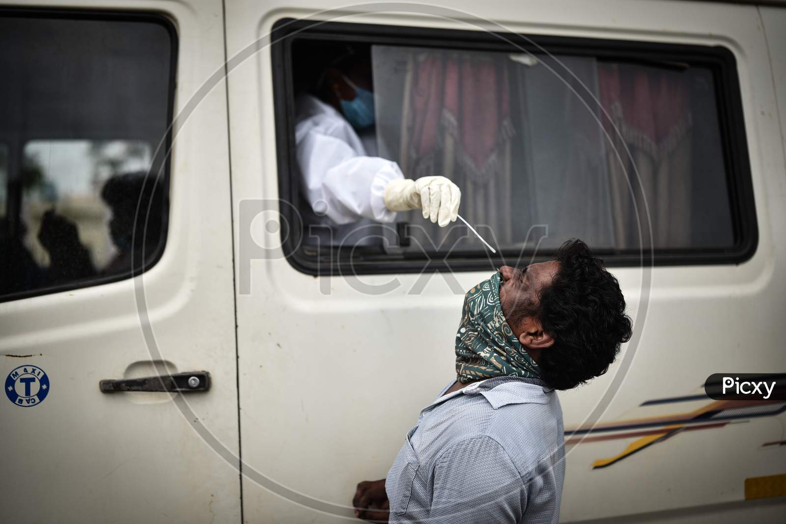A Medic Collects A Swab Sample Of Man For The Covid-19 Test From A Swab Collection Van In Vijayawada.