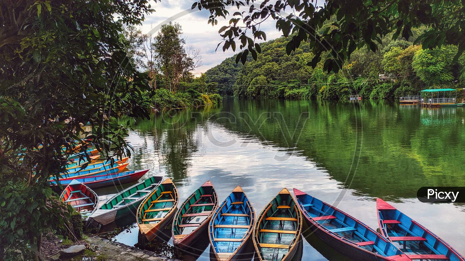 This photo is about a lake with boats resting in the water peacefully.