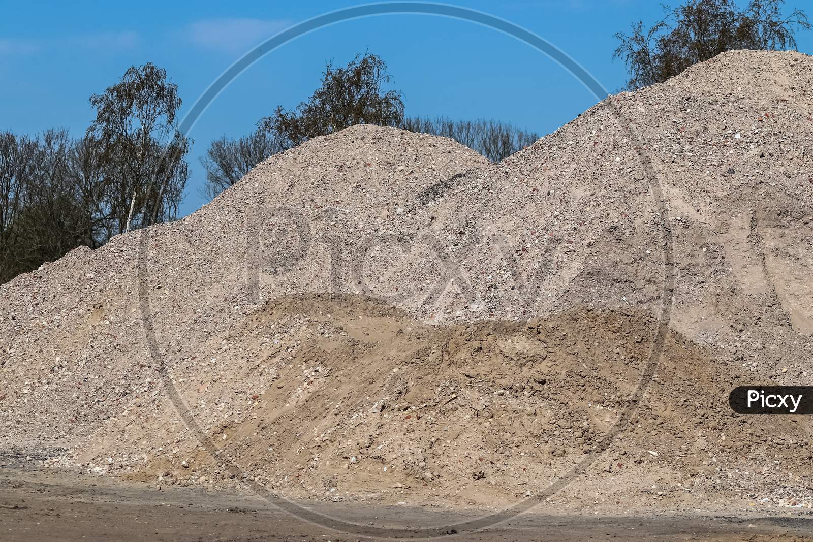 View Into A Gravel Pit With Piles Of Sand And Some Tire Tracks
