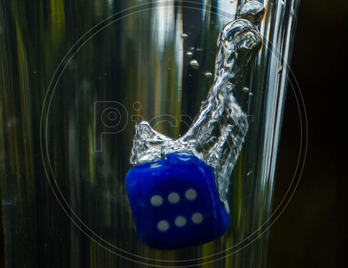 Dice thrown in a glass of water . Fast shutter speed photography .
