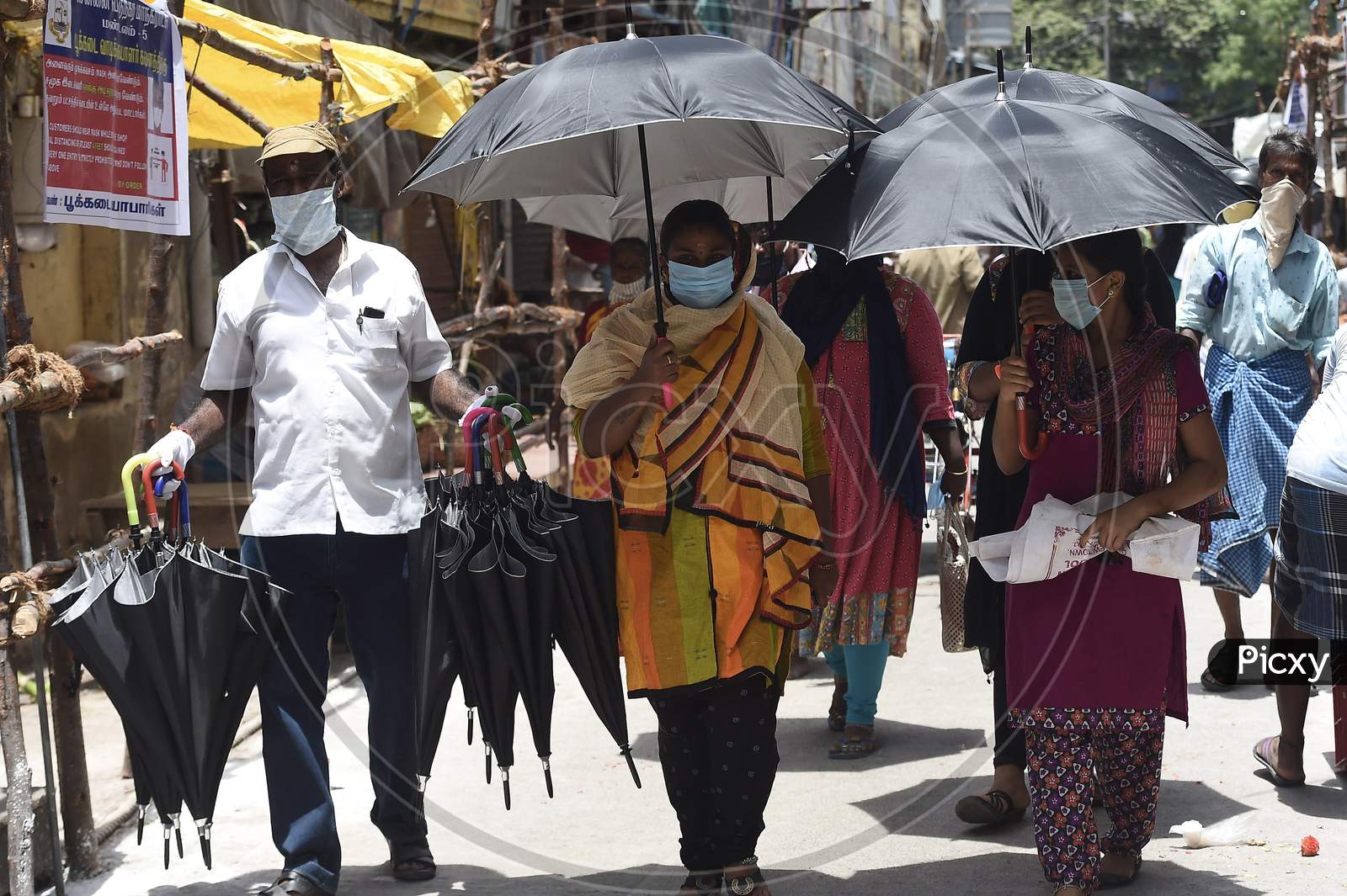 People Hold Umbrellas As They Shop For Flowers At A Market, In Chennai, Monday, July 27, 2020.