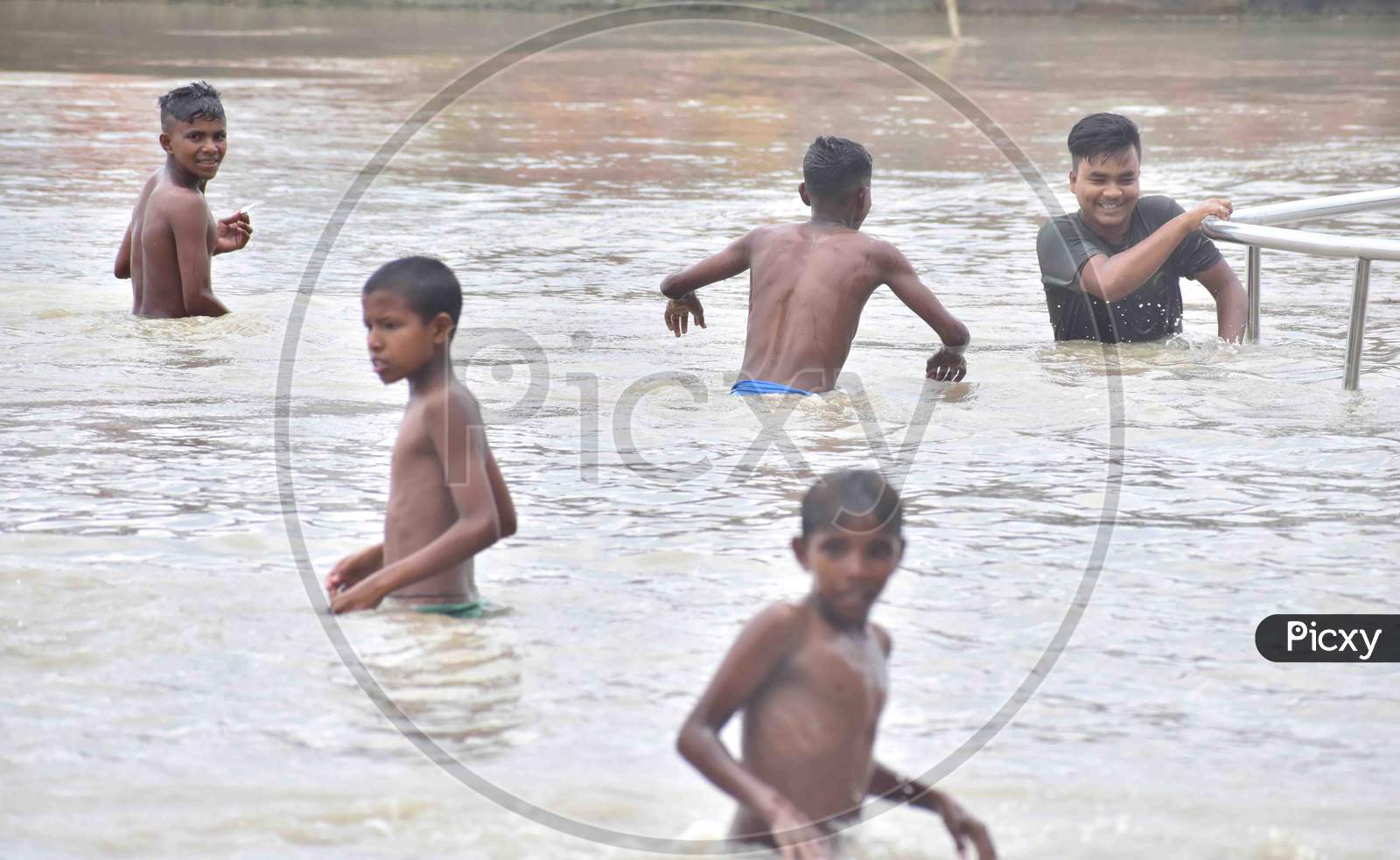 Boys swim and play at flooded Brahmaputra
