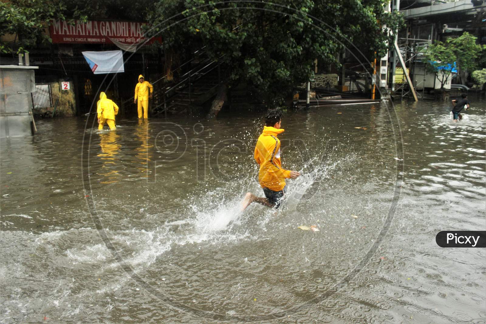 A boy runs on waterlogged road during rains, in Mumbai, India, July, 2020.