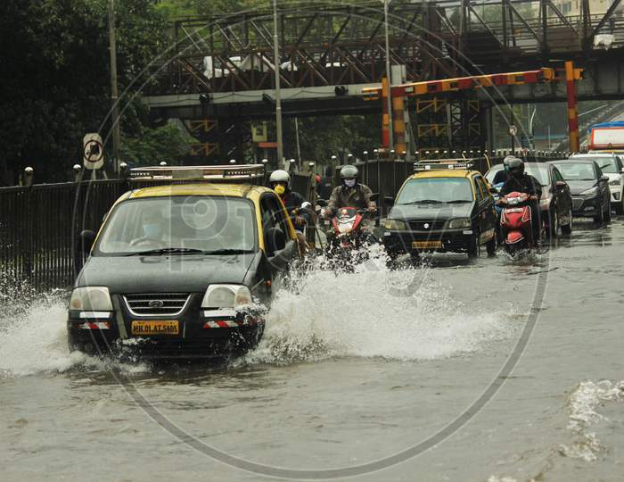 Vehicles pass through a waterlogged road during rains, in Mumbai, India, July 2020.