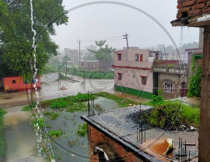 Monsoon in India and monsoon fun. Raining cats and dogs in Bihar India leading to stagnant water everywhere. White clouds full of water.