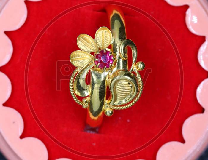A Red Diamond Gold Ring Featuring A Flower Design And Beautifully Drawn Artwork For The Girl
