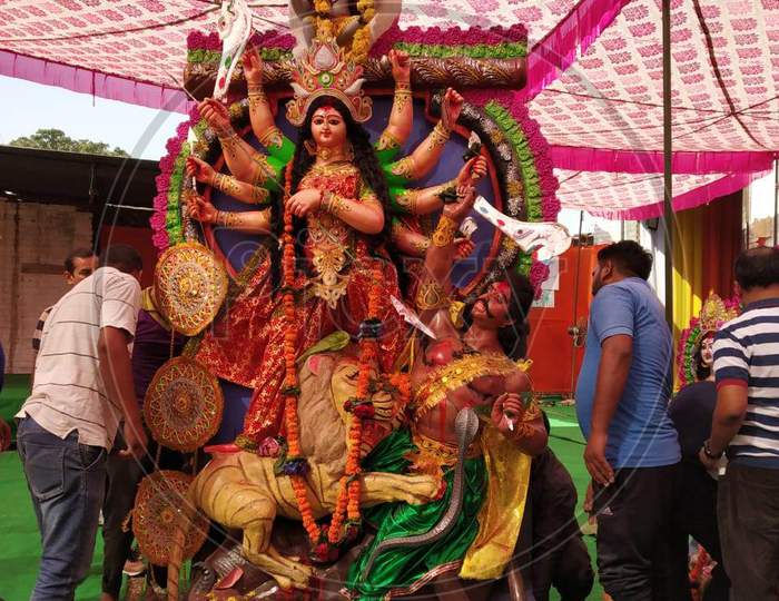 people lifting an idol of Goddess Durga for immersion