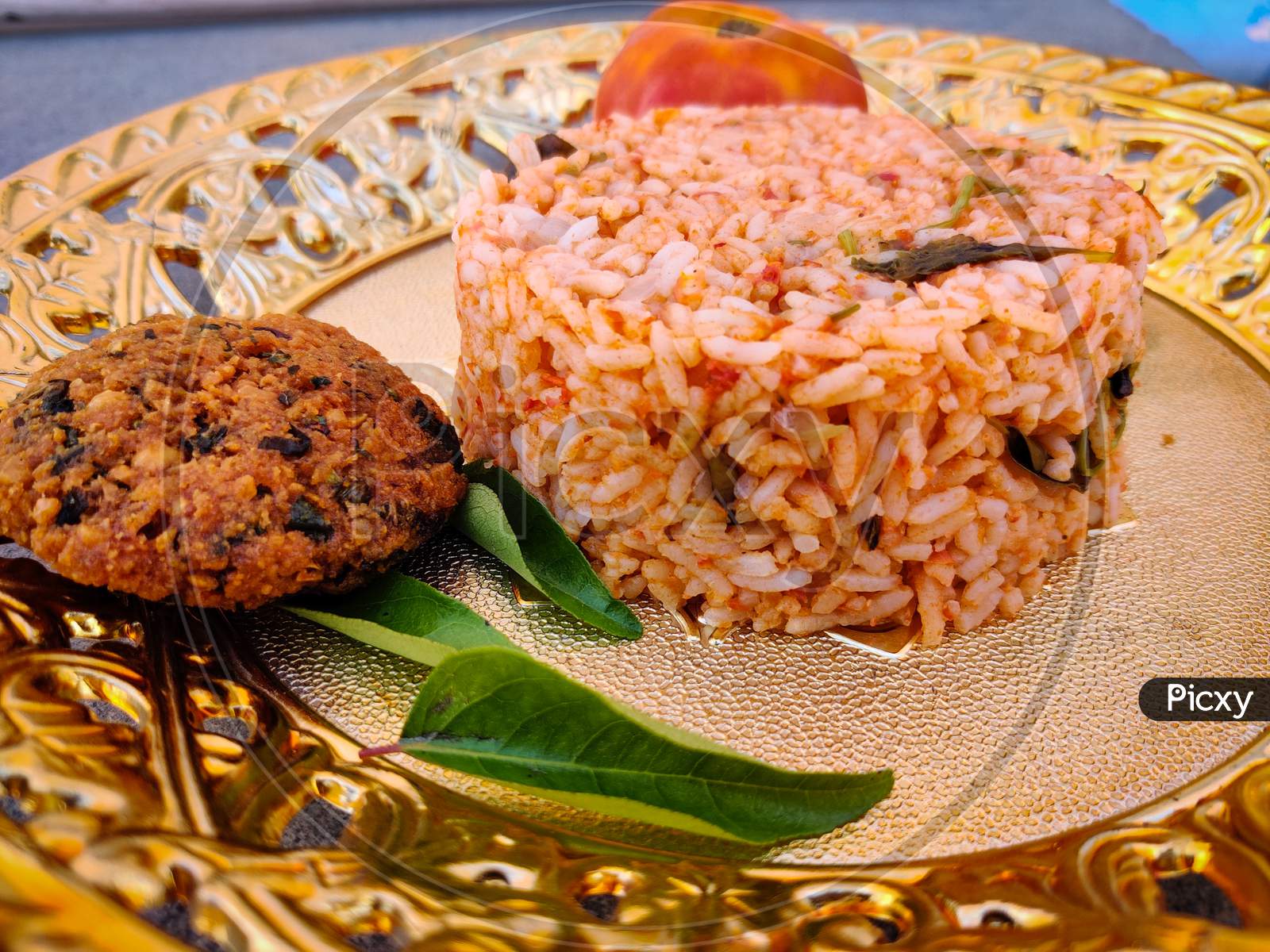 Tasty Tomato Rice With Vada Kept In Gold Plate. A South Indian Recipe.