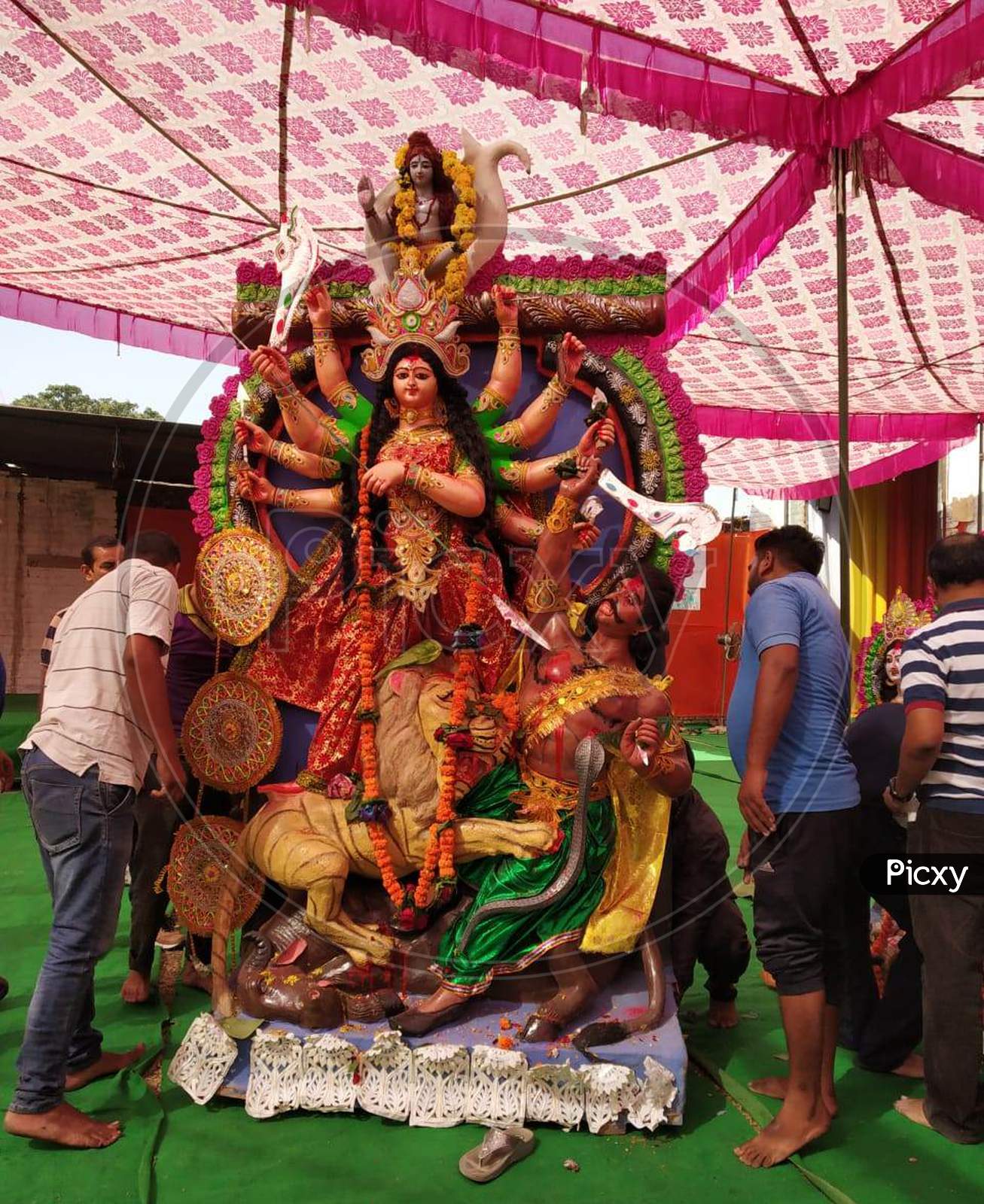 people lifting an idol of Goddess Durga for immersion