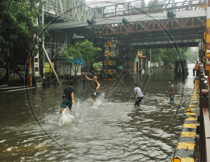 Kids play on a waterlogged road during rains, in Mumbai, India, July, 2020.
