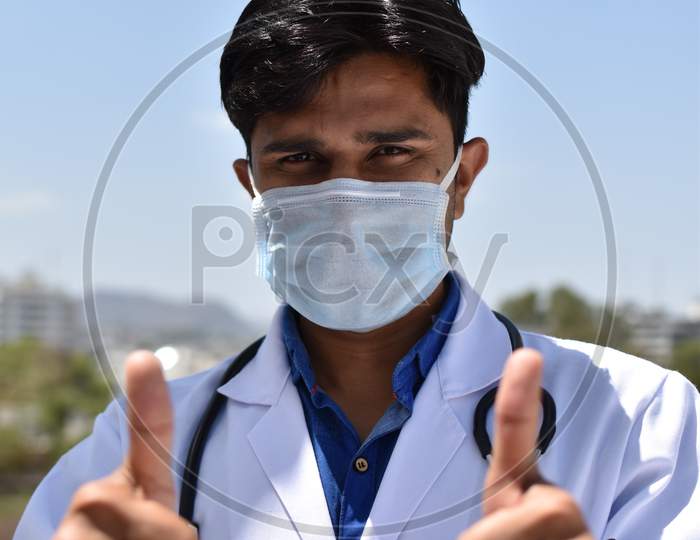 indian young  doctor with blue mask and white coat