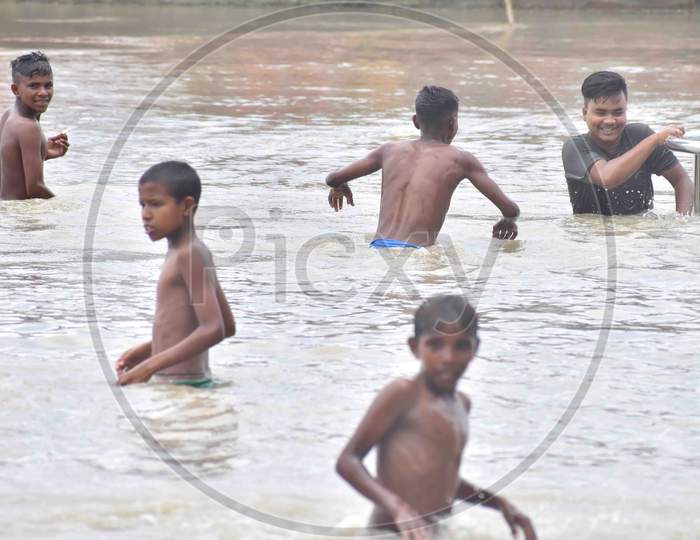Boys swim and play at flooded Brahmaputra