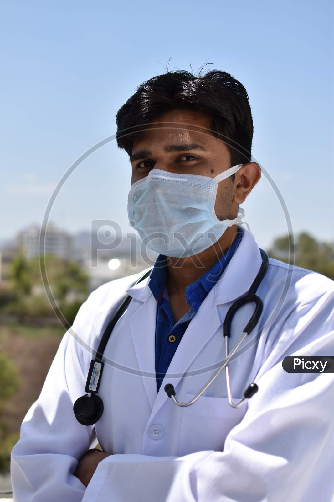 indian young  doctor with blue mask and white coat