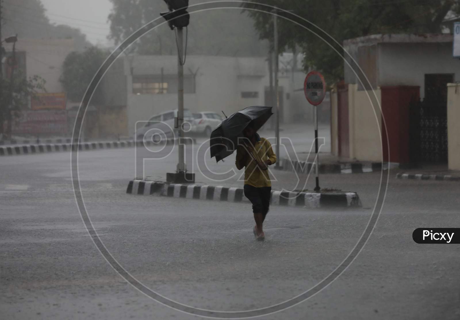 A man walks down the street during monsoon rains on the outskirts in Jammu on July 29, 2020.