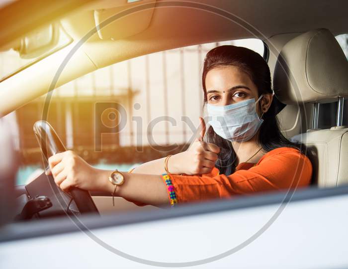 Indian Young Woman Or Girl Wearing Face Mask While Driving Car