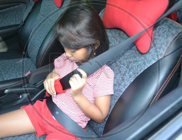 Little Girl Hold Seat Belt And Have Difficulty In The Car