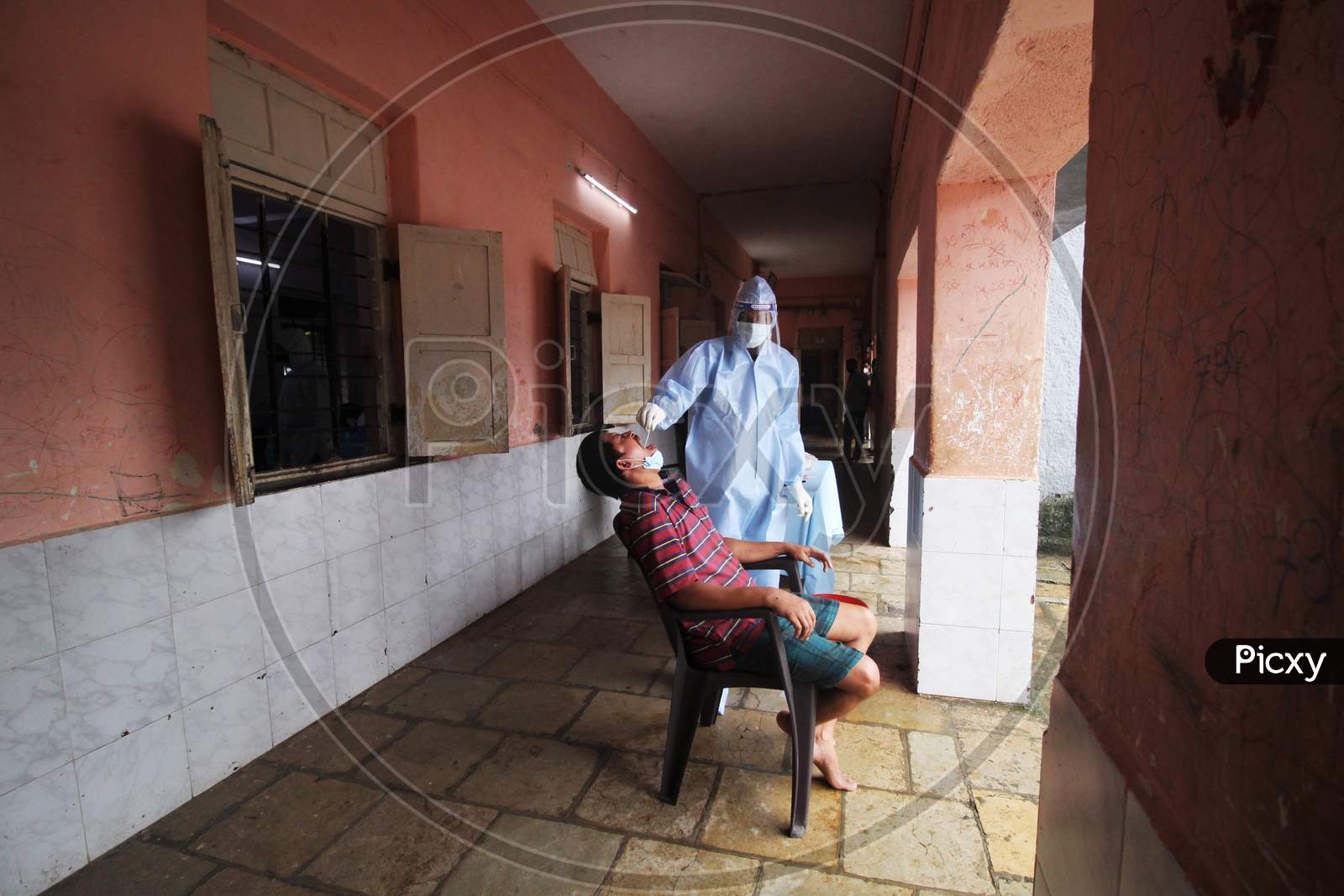 A healthcare worker wearing personal protective equipment (PPE) collects a swab sample from a man during a check-up campaign for the coronavirus disease (COVID-19), in Mumbai, India on July 28, 2020.