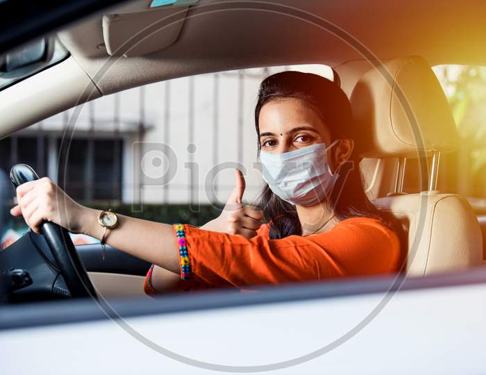 Indian Young Woman Or Girl Wearing Face Mask While Driving Car