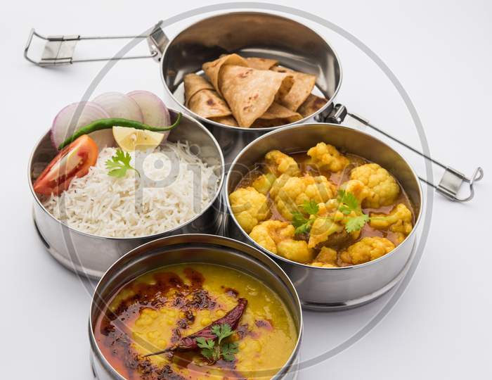 Indian Lunchbox Or Tiffin Includes Cauliflower Masala, Dal Fry, Rice, Chapati And Salad