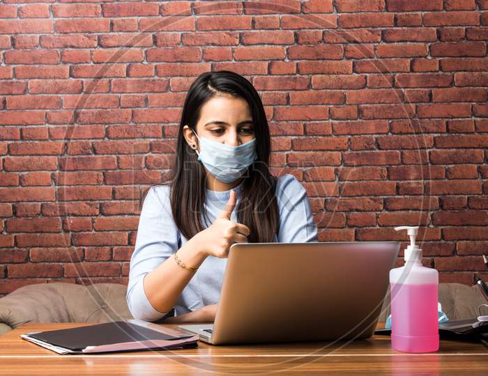 Indian Pretty Girl Working Or Studying Using Laptop Wearing Face Mask