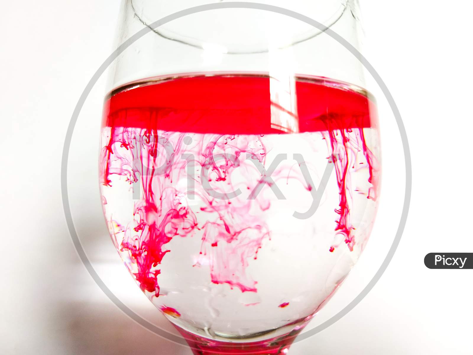 Red ink in a glass of water.