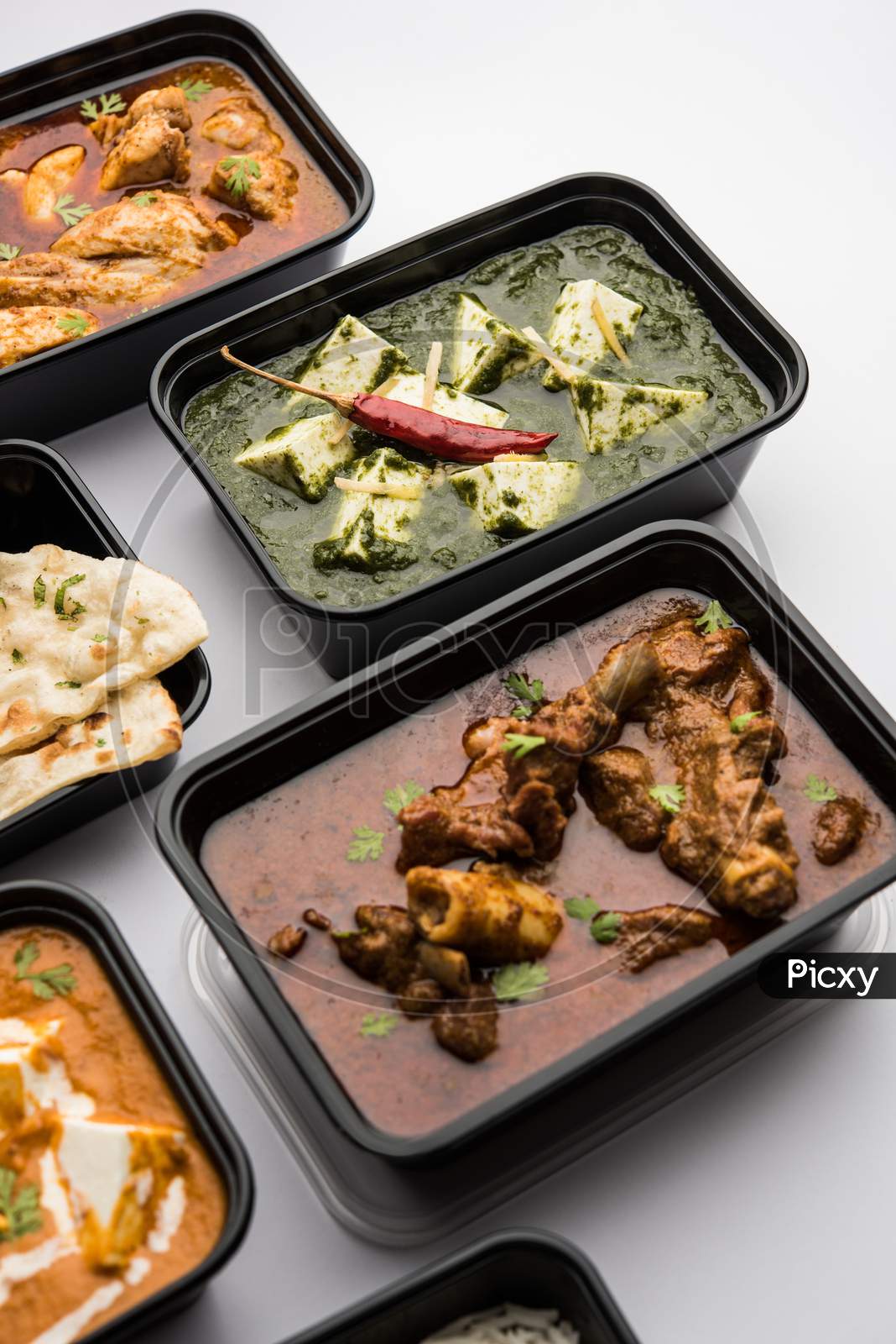 Indian Chicken & Mutton Curry With Paneer Butter Masala And Spinach Curry In Plastic Boxes For Home Delivery