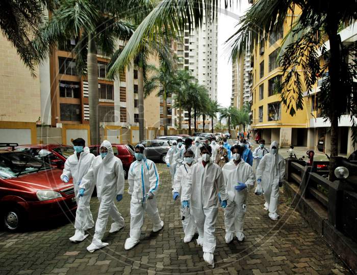 Healthcare workers wearing personal protective equipment (PPE) arrive on spot for screening, at a residential building, during a check-up campaign for the coronavirus disease (COVID-19), in Mumbai, India on July 26, 2020.