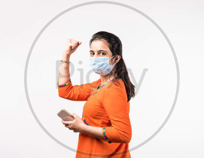Beautiful Indian Woman Talking On Her Cell Phone While Wearing Protective Medical Mask