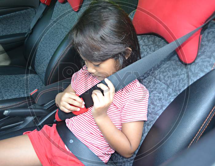 Asian Little Girl Holding The Seat Belt And Feel Comfortable In The Car