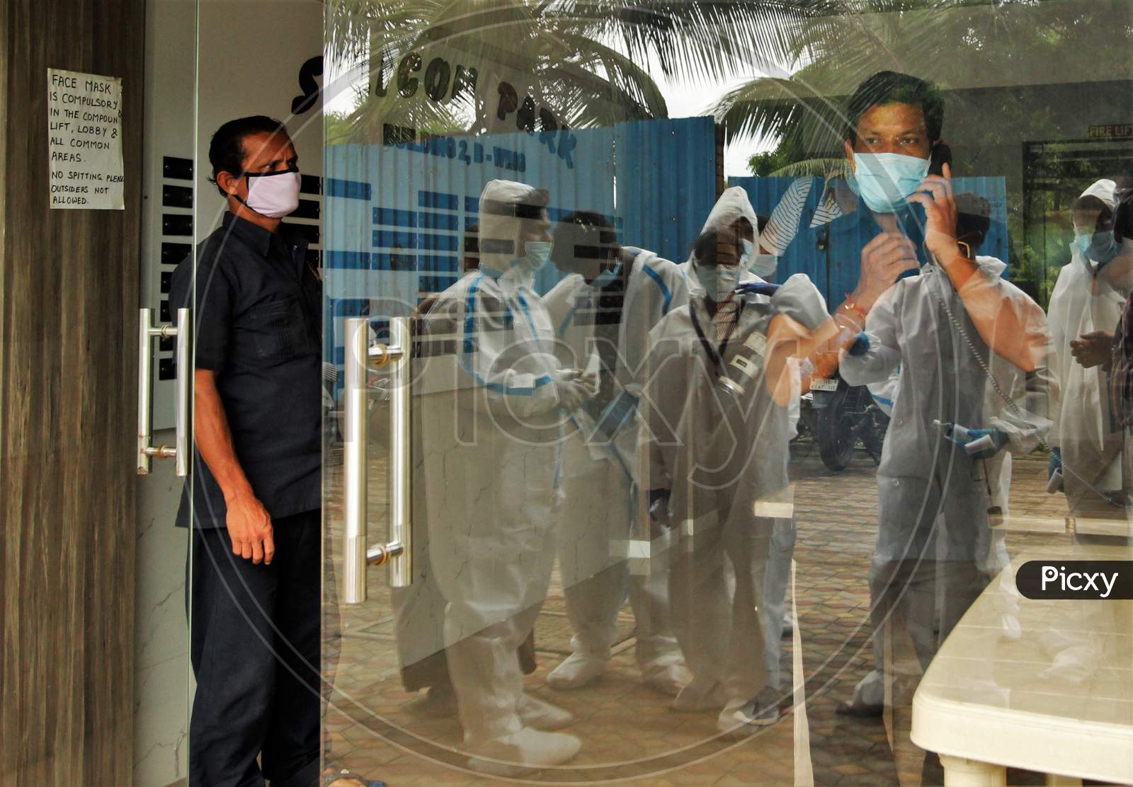 Healthcare workers wearing personal protective equipment (PPE) arrive on spot for screening, at a residential building, during a check-up campaign for the coronavirus disease (COVID-19), in Mumbai, India on July 26, 2020.